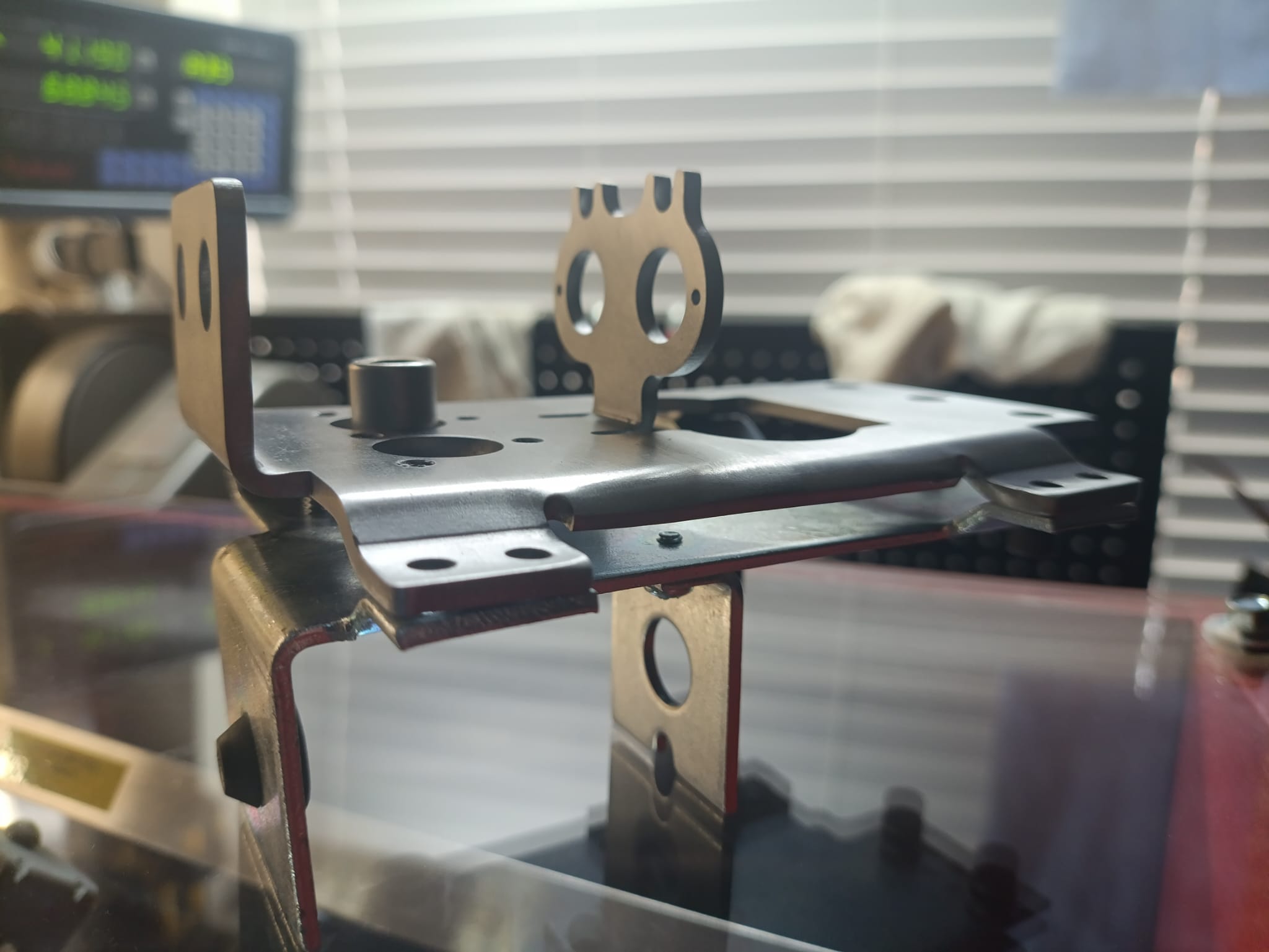 Octane flipper baseplate stacked on top of a Bally/Williams flipper baseplate, showing matching bolt hole patterns