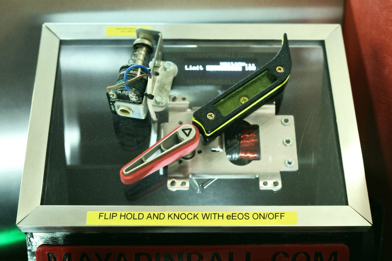 Inside the display case used at UK Pinfest 2026 showing an interactive flipper and knocker rig to promote MAYA Octane flipper technology.